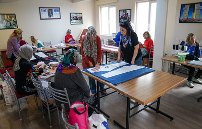 KADINLAR BELDE EVLERİNDE KENDİ KIYAFETLERİNİ ÜRETİYOR